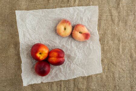 Donut Peaches also known as Saturn peaches and nectarine on a rustic canvas background. Healthy food concept.の写真素材
