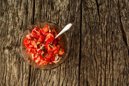 Fresh healthy salad with tomatoes, onions and basil, summer homemade dish. Flat lay background.の写真素材