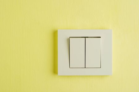 Electric switch with space for text on yellow wallの写真素材