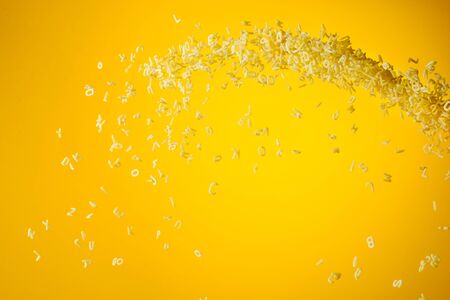 Zero gravity food concept. Flying uncooked pasta on yellow background with copy space.の写真素材