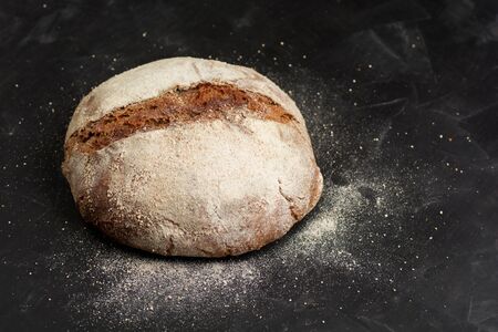 Traditional black rye-bread on dark table with copy space