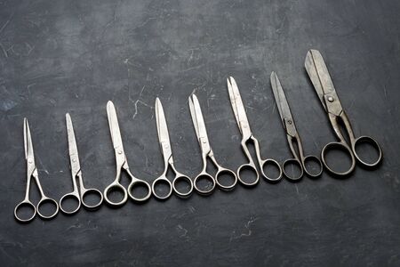 Many different scissors on dark background. Minimal black. Flat layの写真素材