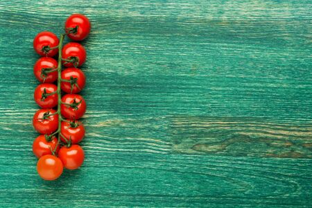 Tomatoes on the vine on rustic wooden background with copy space. Flat lay or top view.の写真素材