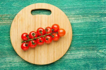 Tomatoes on the vine on rustic wooden background with copy space. Flat lay or top view.の写真素材