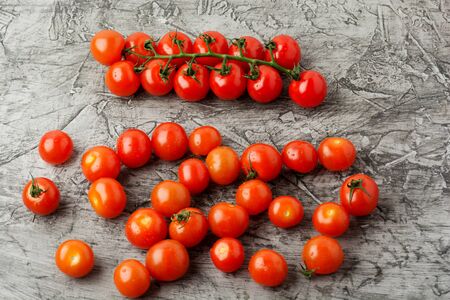 Group of cherry tomatoes on a gray concrete background. Ripe and juicy cherry tomatoesの写真素材