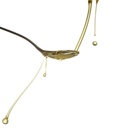 Pouring oil splash. Isolated on white background.の写真素材