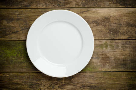 Empty white plate on wooden table close upの写真素材