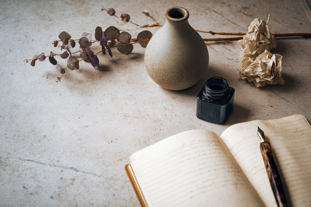 Overhead view of a chaotic creative workspace in nordic style featuring scattered notes and a white ceramic vase. Image created using generative AI.の素材