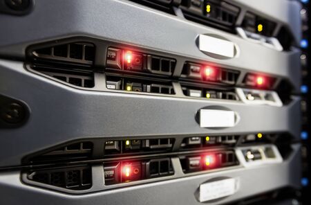 Computer Server mount on rack in data center room with red lighting alarm.