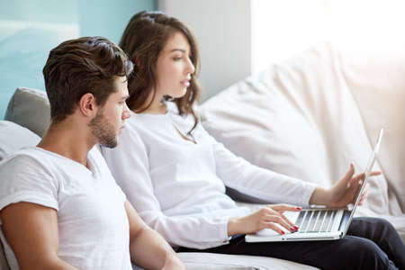 Two young business people in casual wear looking at the laptop. Business people Having Meeting Around Table In Modern Office.の写真素材