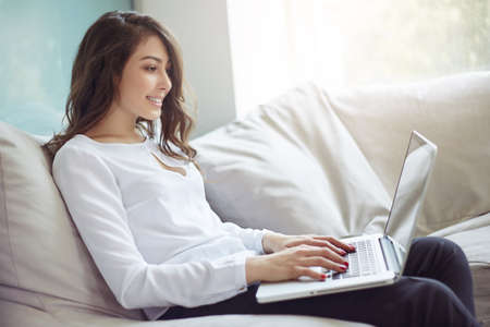 Businesswoman at workplace. Side portrait of beautiful woman in modern business office. Young business woman working in office. Green office. Life style.の写真素材