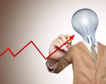 Young businessman with lamp-head and marker writting red graph on screenの写真素材