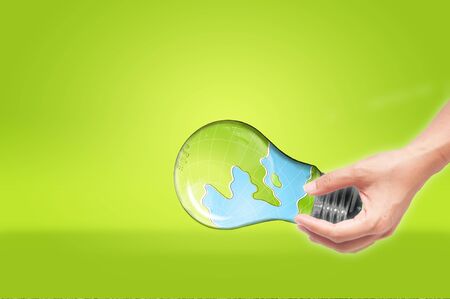 hand holding Bulb with earth inside isolated on white background , green eco conceptの写真素材
