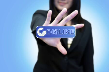 Business woman with hand touching DISLIKE button on touch screenの写真素材