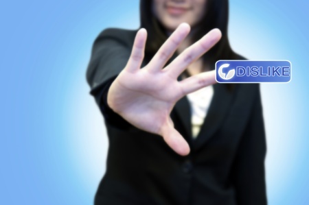 Business woman with hand touching DISLIKE button on touch screen の写真素材