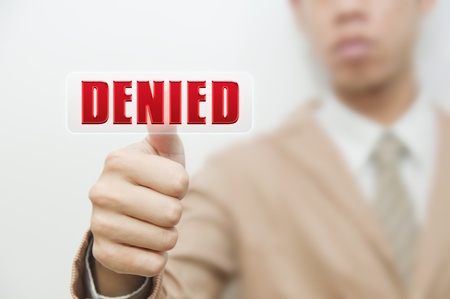 Business man pressing touch screen on denied buttonの写真素材