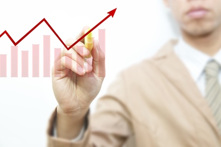 Young business man drawing red graph and chart, isolated over white background の写真素材