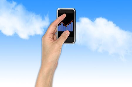 Hand with graph and touchscreen device showing business and investment conceptの写真素材