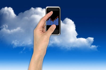 Hand with graph and touchscreen device showing business and investment conceptの写真素材