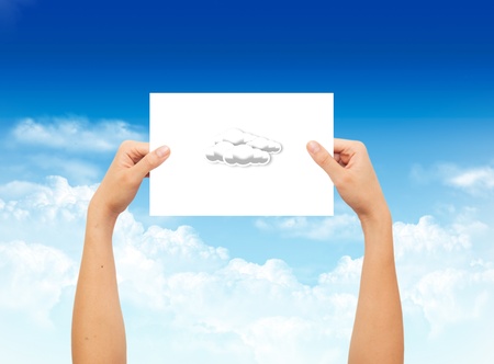 Hand holding a paper with weather sign on landscape blue sky background