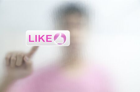 Man put finger pressing Social Network icon on like buttonの写真素材