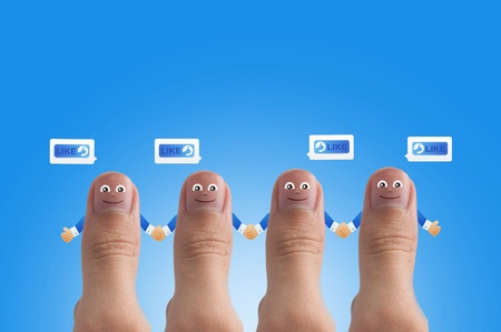 Smiling cartoon face on human thumb up on backgroundの写真素材