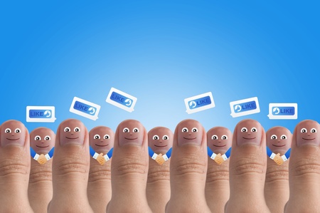Smiling cartoon face on human thumb up on background, SOCIAL NETWORKの写真素材