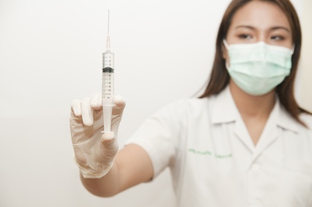 A medical doctor preparing an injection in a syringeの写真素材