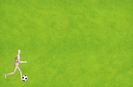 Wood puppet playing soccer with ballの写真素材