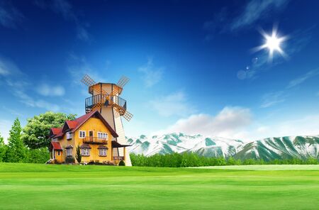 House on green field landscape with bule sky and sunの写真素材