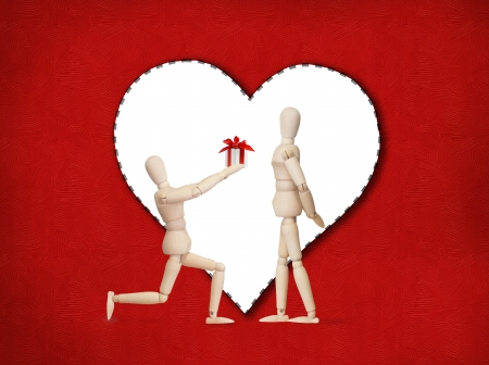 Wooden model handing over love gift to friend on Valentine dayの写真素材