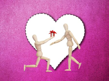 Wooden model handing over love gift to friend on Valentine dayの写真素材
