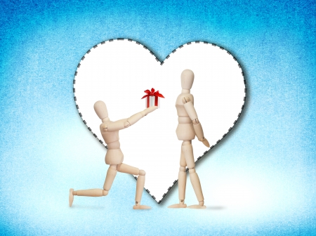 Wooden model handing over love gift to friend on Valentine dayの写真素材