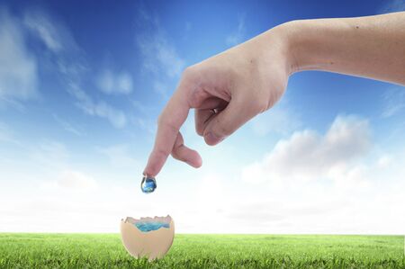 Drop of water with Earth inside and hand. The symbol of Save Planetの写真素材