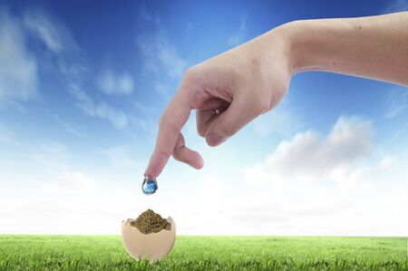 Drop of water with Earth inside and hand. The symbol of Save Planetの写真素材