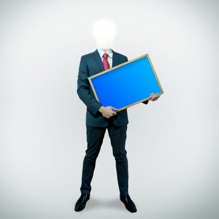 Business man with bulb head holding black board on the screen backgroundの写真素材
