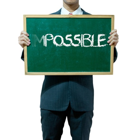 Business man holding blackboard on the background , Impossibleの写真素材