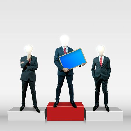 Business man with bulb head holding black board on the screen backgroundの写真素材