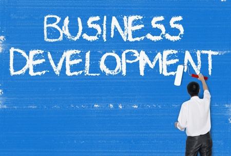 Man painting word on cement texture wall background, Business managementの写真素材