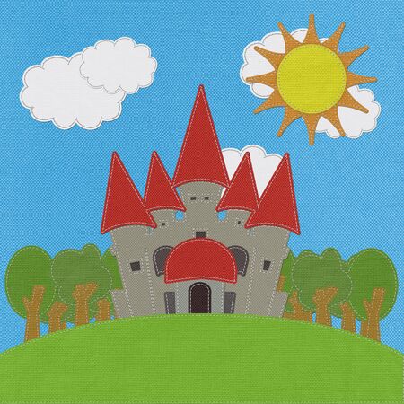 Fairy-tale castle on a green field with stitch style on fabric backgroundの写真素材