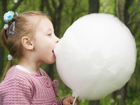 Girl eating cotton candyの写真素材