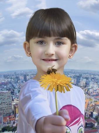 Girl hold yellow dandelion with bee city backgroundの写真素材
