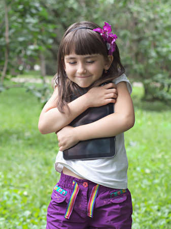 Girl with tablet pc in the meadowの写真素材