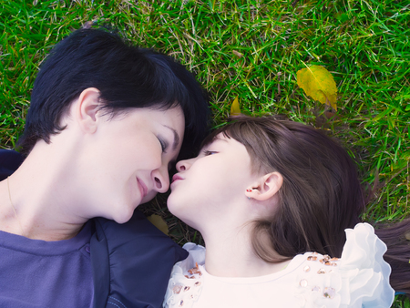 Mother and daughter lie on the grassの写真素材
