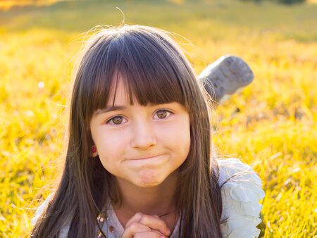Child lying on the grass in autumn parkの写真素材