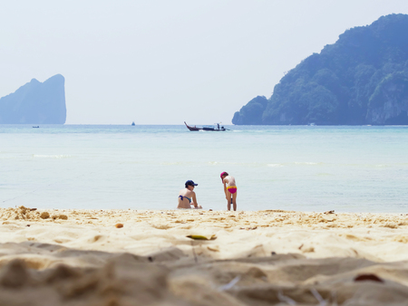 Mother and her little daughter on tropical white sand beach on islandの写真素材