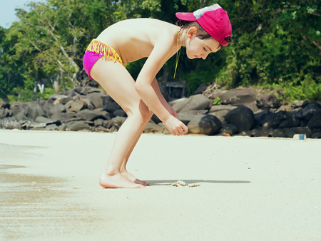 Beach tropical vacation caucasian kid girl with playing at the sandの写真素材