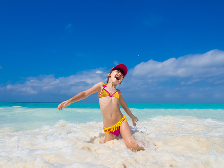 Beach tropical vacation caucasian kid girl with playing in the seaの写真素材