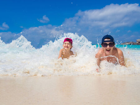 Mother and her little daughter on tropical white sand beach on islandの写真素材