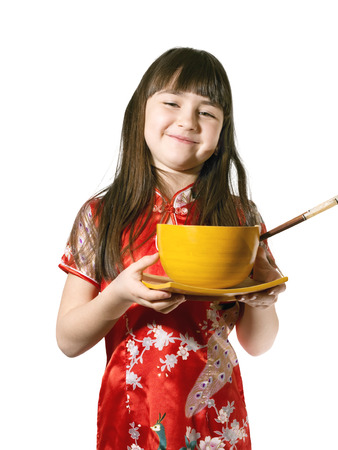 Portrait of caucasian little girl in vietnamese national costume keep wooden bowl and plate isolated on whiteの写真素材